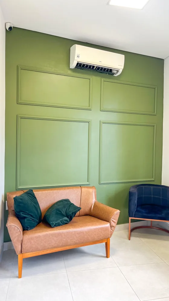 Boiserie em parede verde com composição de molduras.